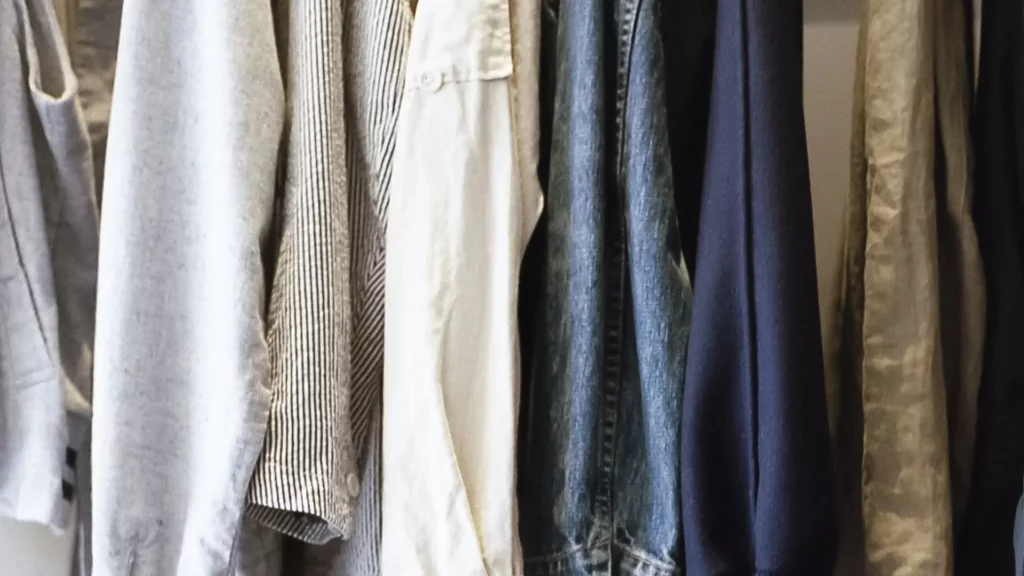 close up shot of various shirts and tops hanging on a clothes rail