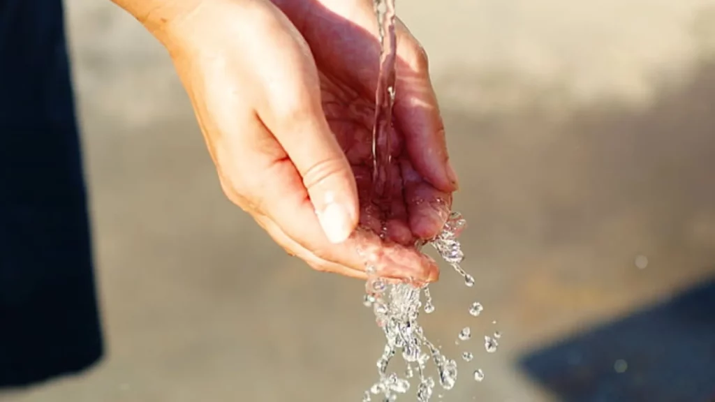 Clean fresh water pouring through a woman's hands