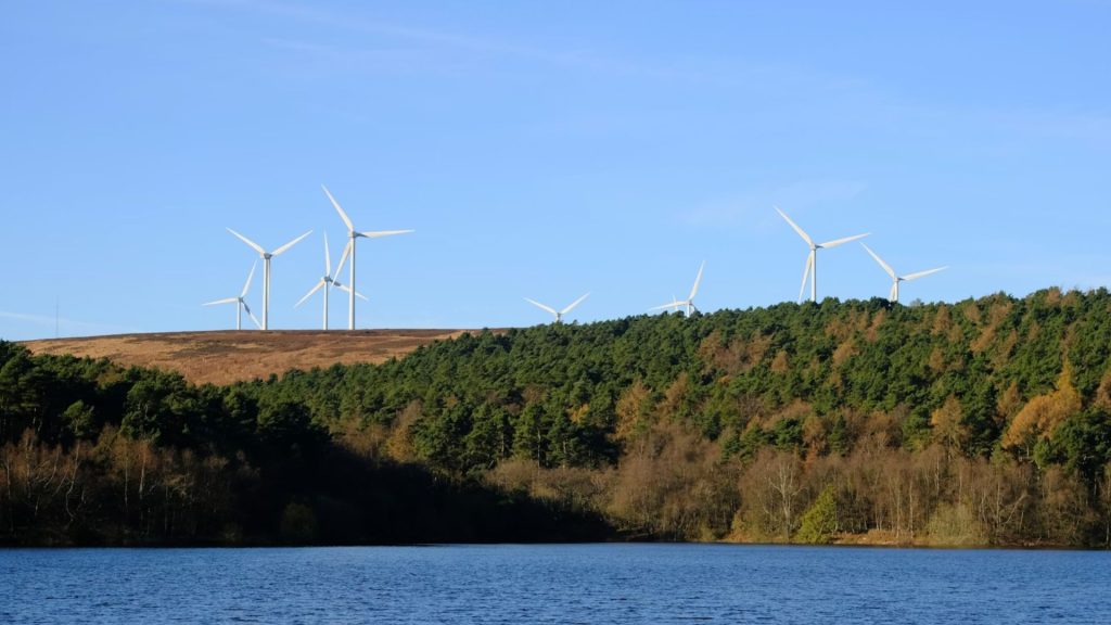 Wind farm with forest and lake in the foreground
