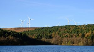 Wind farm with forest and lake in the foreground